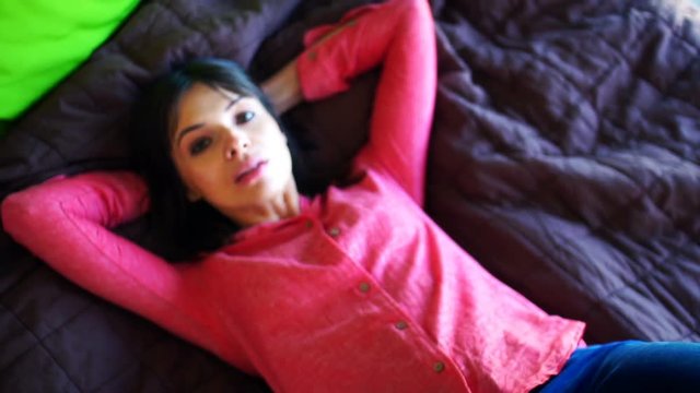 Happy, pretty woman falling on bed at home, super slow motion 240fps
