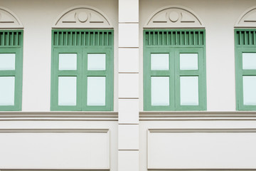 Building wall in classic style with green windows