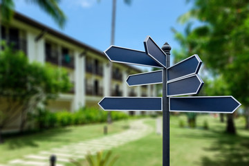 Blank sign label on a pole with blurred hotel resort background