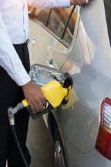 african male pumping gas at station