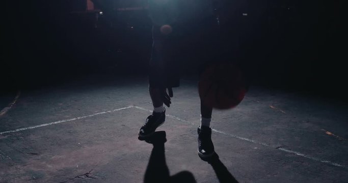 Male Basketball Player Dribbling Ball on Court in Evening