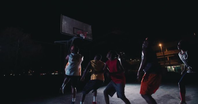Basketball Players Playing in Court During Nighttime