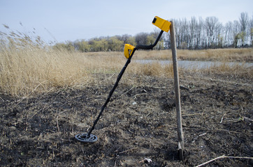 the metal detector with a shovel outdoors
