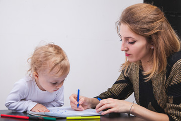 mother and her kid girl pencil together