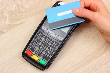 Hand of woman paying with contactless credit card with NFC technology, finance concept