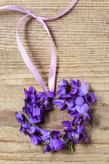 Small door wreath with tiny violets (viola odorata flowers) on w