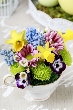 Floral arrangement inside vintage ceramic cup