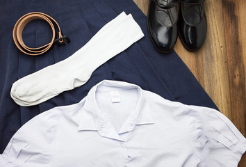 Still life : Thai Student girl uniform with wooden background on top view