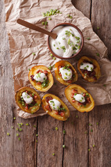 potato skins with cheese, bacon and sour cream on the table. vertical top view
