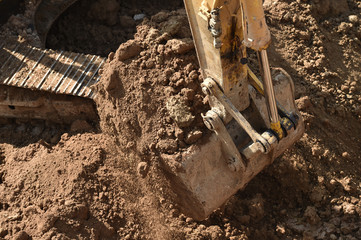 Fototapeta na wymiar Working excavator that loads ground on construction site 
