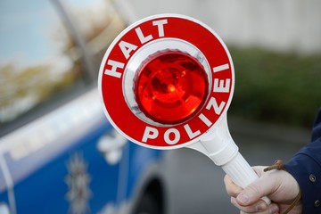 Kelle vor Polizeiwagen