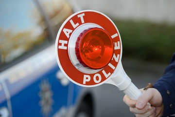 Kelle vor Polizeiwagen