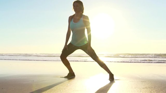 Woman Working out on Beach at Sunset. Stretching. Fitness. Tying Shoes, Active Lifestyle. Slow Motion