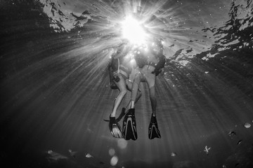 beautiful diver underwater with sun rays