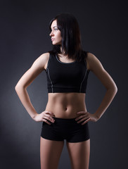 Fototapeta na wymiar Fitness woman standing against black background