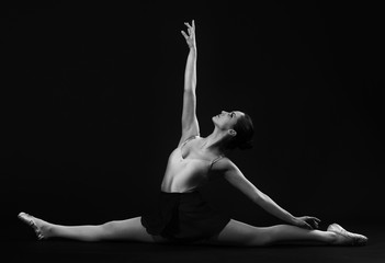 Ballerina sitting on the splits .Grayscale image.