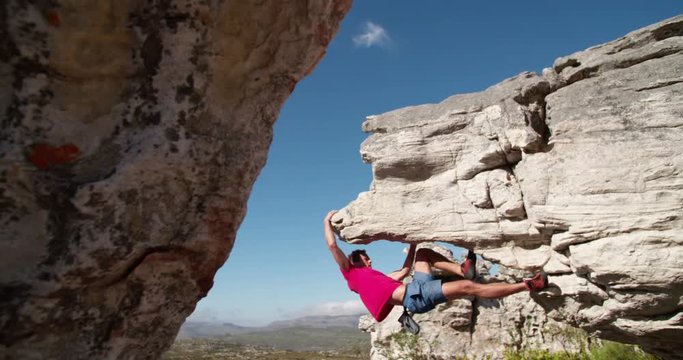 Rock climber holding to boulder and focused on route
