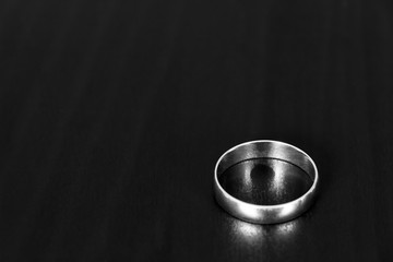A wedding ring on a black table