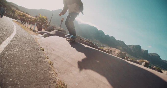 Skater Jumps off Side of Street Curb During Sunset