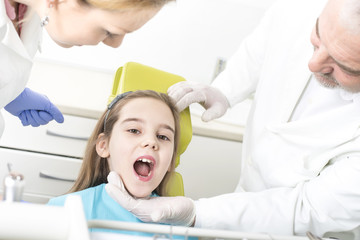 Close up of girl with open mouth having teeth examination at dental clinic. People, medicine, stomatology and health care concept