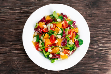 Fresh Orange, vegetables salad on wooden table.