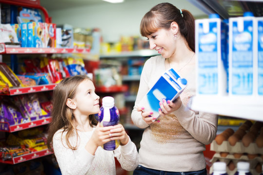 Woman With Daughter Buying Milk