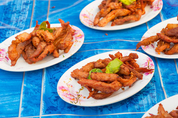 Thai fried pork jerky on plate on table sale at stall