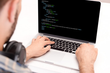 Man using laptop, writing programming code on laptop