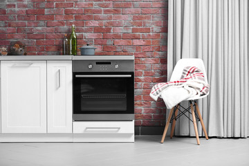 Modern kitchen furniture against brick wall background