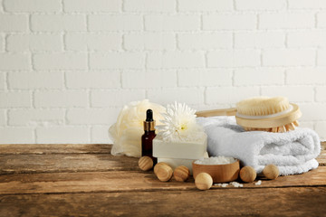 Fototapeta na wymiar Variety of natural bath tools on wooden table, on bricks wall background