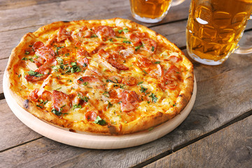 Delicious pizza  and glasses of beer are on wooden table, close up