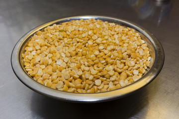 metal bowl with yellow lentils husked