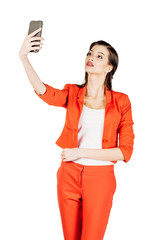 Naklejka premium business woman wearing an orange shirt using a smartphone. 
