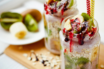 Healthy breakfast over night oats with fresh fruit kiwi and bananas in a glass jar. Beautiful oatmeal