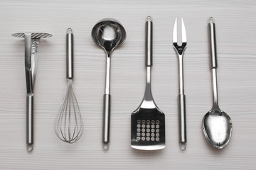 Set of metal kitchen utensils on wooden table