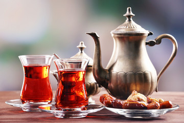 Black tea in glass cups and eastern sweets on wooden table