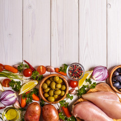 Chicken breast with fresh vegetables and spices for cooking.