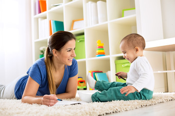 Fototapeta premium Happy smiling family drawing together on floor