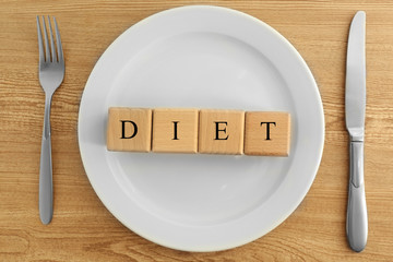 White plate with cubes on wooden background