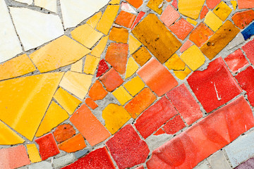 colorful mosaic of ceramic pieces on the wall, typical art Gaudi style in Barcelona, Spain	