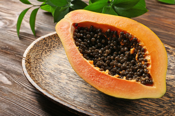 Halved papaya on a wooden plate