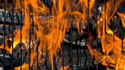 Empty Flaming Charcoal Grill With Flames Of Fire On Black Background Closeup. Summer Outdoor Barbeque Party or Picnic Concept.
