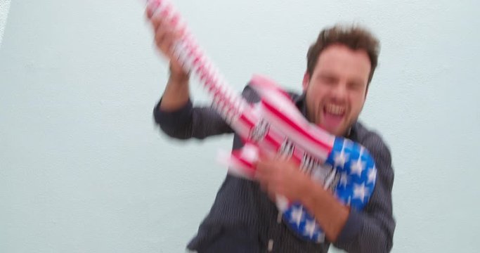 Silly young man playing inflatable guitar