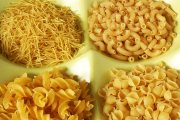 Dried pasta variety in shapes in bowl. Close-up
