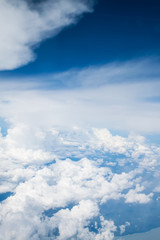 Airplane above clouds and island Indonesia.