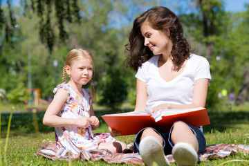 girl and a young woman reading a book together