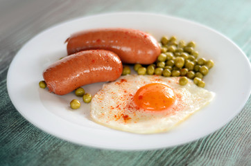 sausages , fried egg and peas