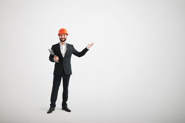Man in formal wear and a construction helmet pointing in the dir