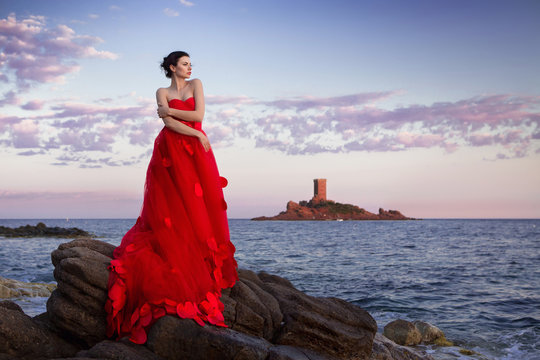 Junge Frau im sch&ouml;nen roten Fashion Kleid am Meer in St. Raphael Frankreich