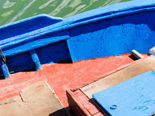 Fototapeta na wymiar bottom of the boat, details of a small boat painted in red and blue